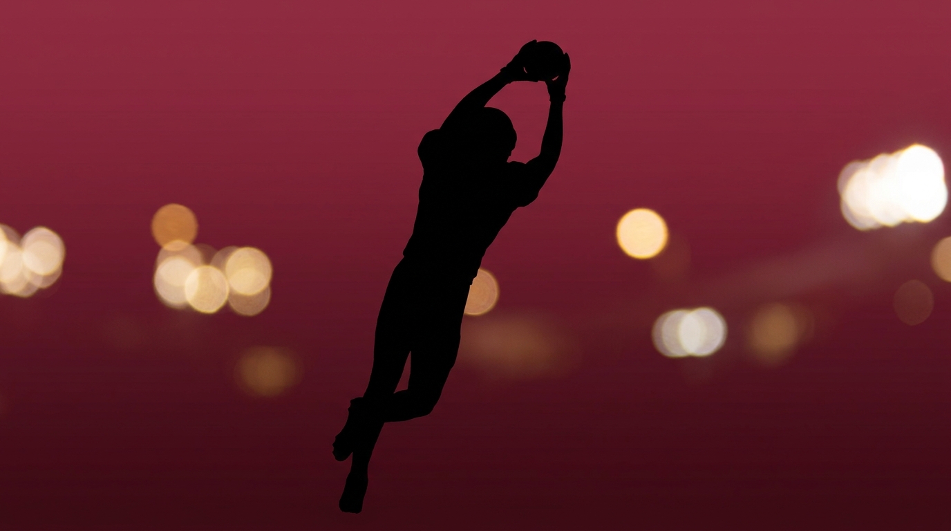 Silhouette of a wide receiver leaping to catch a football against a maroon gradient background